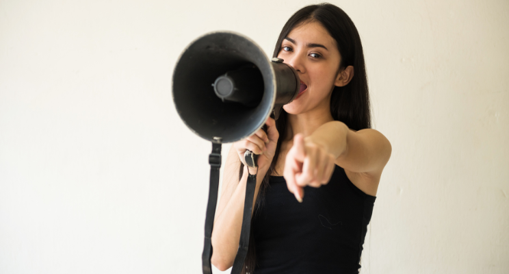 woman with megaphone pointing a finger